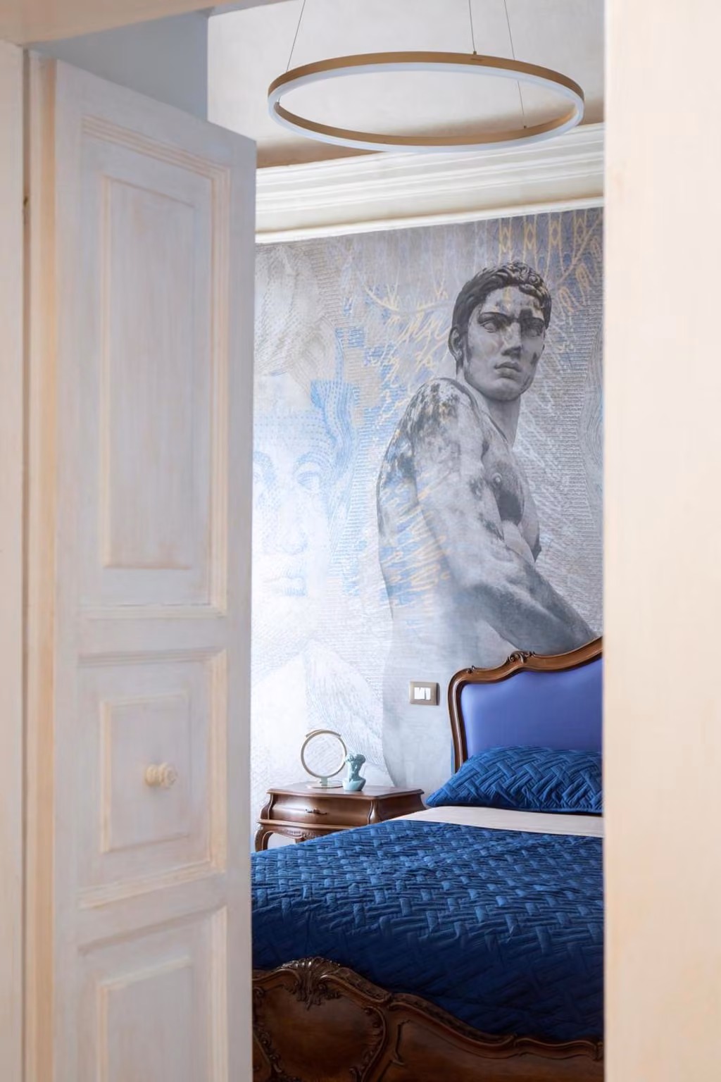 Un dipinto di un uomo sulla parete accanto al letto di una camera