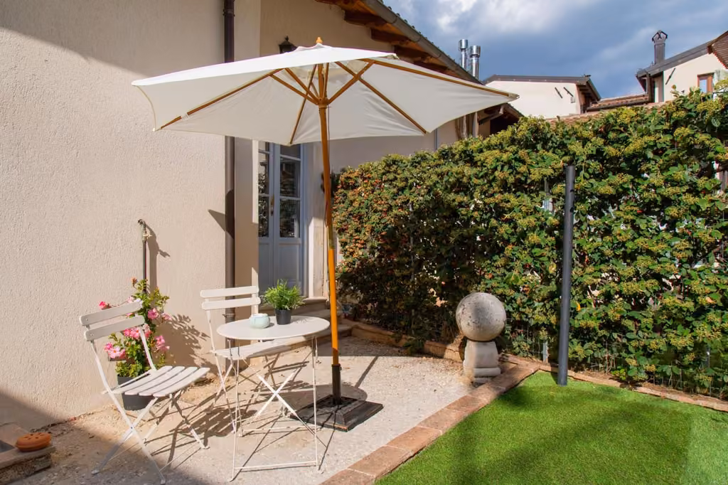 Il patio con ombrellone, tavolo e sedie