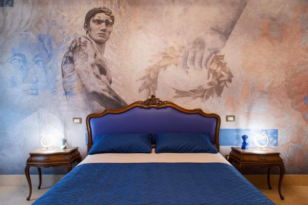 Una camera da letto del B&B Palazzetto Alfieri, con il letto blu e un quadro sulla parete