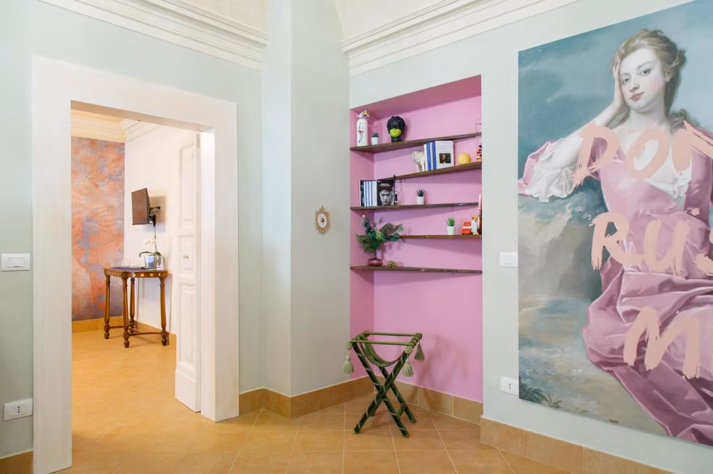 Una stanza del B&B con un grande dipinto di una donna sul muro